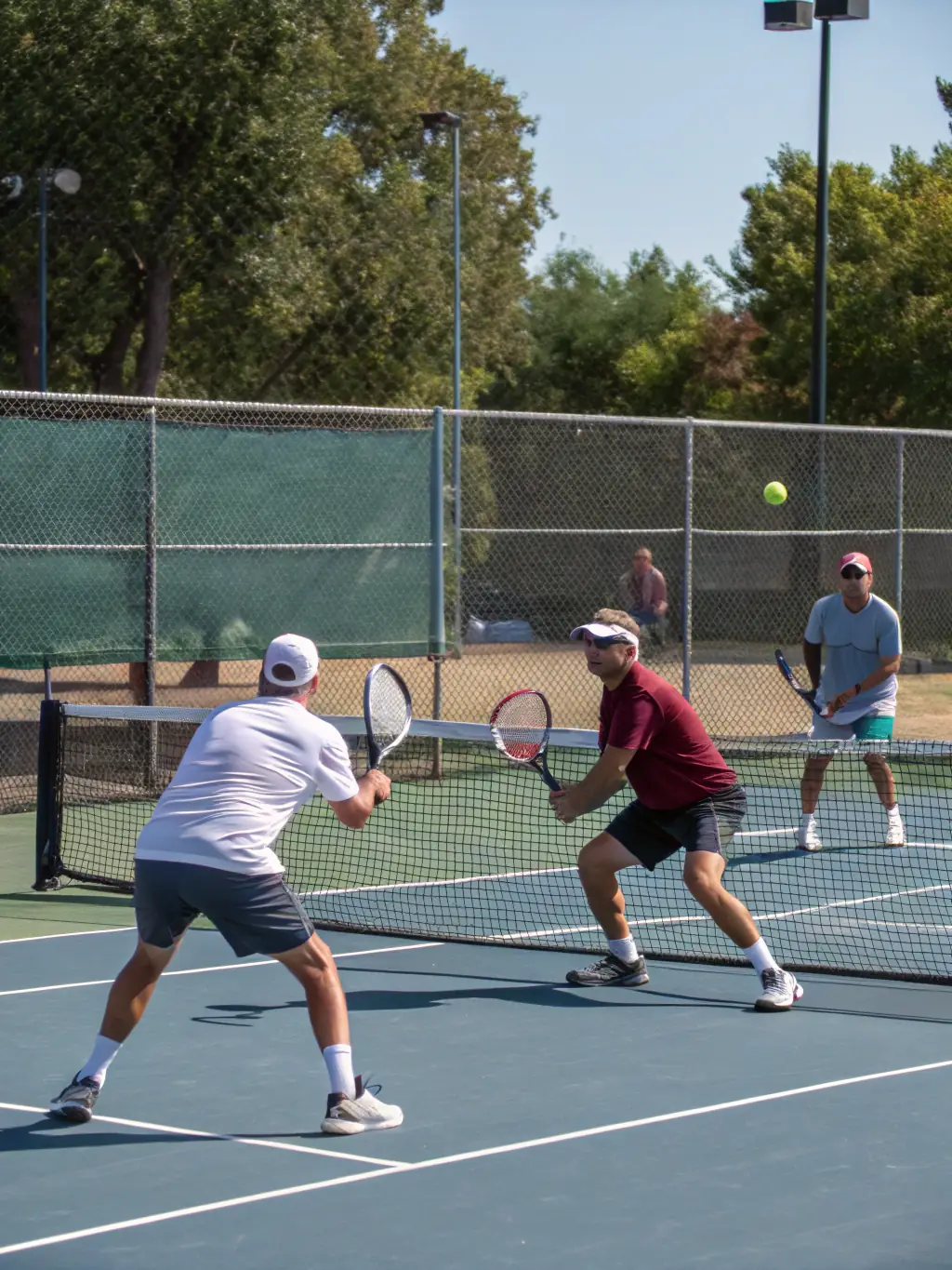 A dynamic shot of adult players engaged in a competitive doubles match during a club tournament at ASS ERVY TENNIS.